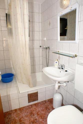 a bathroom with a tub and a sink and a toilet at Apartments with parking space Sutivan, Brac - 745 in Sutivan
