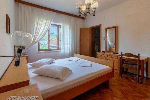 a bedroom with a bed with a desk and a mirror at Apartments by the sea Sumartin, Brac - 758 in Sumartin