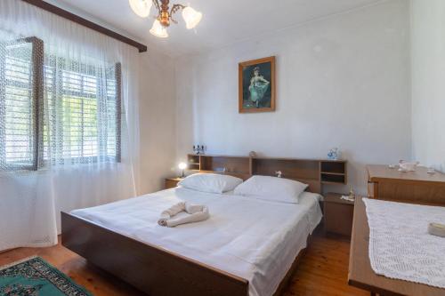 Un dormitorio con una cama grande con sábanas blancas. en Apartments by the sea Sumartin, Brac - 764, en Sumartin