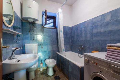 Un baño azul y blanco con lavabo e inodoro. en Apartments by the sea Sumartin, Brac - 764, en Sumartin