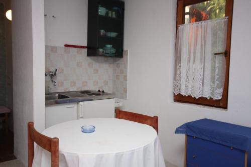 a kitchen with a white table and a sink at Apartments by the sea Maslinica, Solta - 772 in Grohote