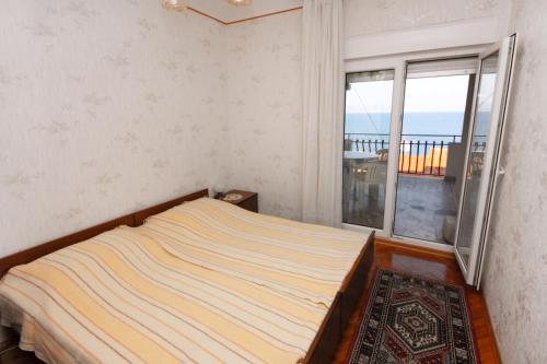 a bedroom with a bed and a large window at Apartments by the sea Stomorska, Solta - 778 in Stomorska