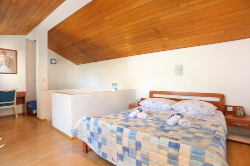 un dormitorio con una cama con dos animales de peluche en Holiday house with a parking space Brela, Makarska - 788, en Brela