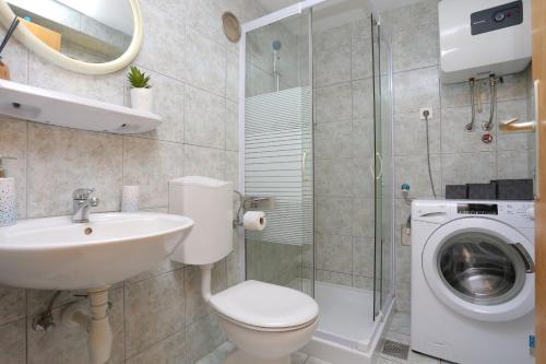 y baño con lavamanos y lavadora. en Holiday house with a parking space Brela, Makarska - 788, en Brela