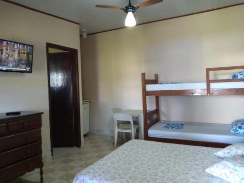 a bedroom with two bunk beds and a table at Cantinho da Geisa - suítes mobiliadas in Bertioga