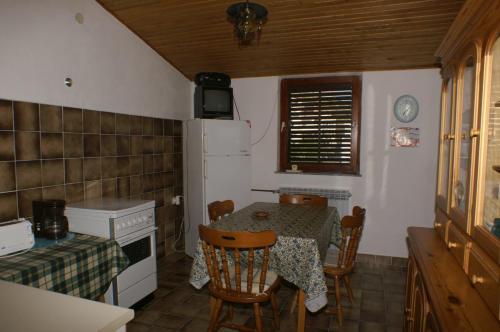 a small kitchen with a table and a refrigerator at Apartment Duce 945b in Duće