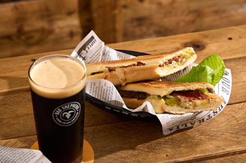 a sandwich in a basket next to a glass of beer at View Melbourne in Melbourne