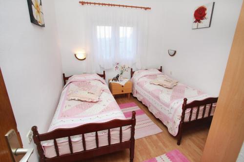 two beds in a small room with white walls at Apartments by the sea Slatine, Ciovo - 972 in Trogir