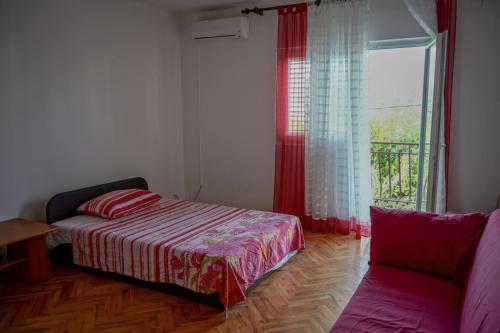 een slaapkamer met een bed, een raam en een bank bij Apartments with a parking space Slatine, Ciovo - 973 in Slatine