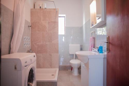 een badkamer met een wasmachine en een wastafel bij Apartments with a parking space Slatine, Ciovo - 973 in Slatine