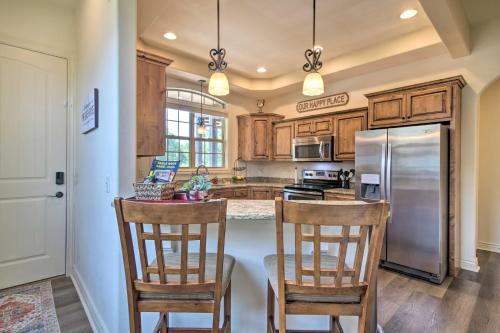 a kitchen with wooden cabinets and a stainless steel refrigerator at Luxe Mtn-View Condo in Branson with Hot Tub Access! in Branson