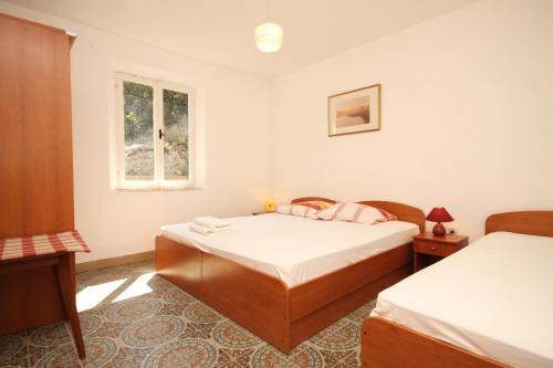 um quarto com 2 camas e uma janela em Apartments and rooms by the sea Lucica, Lastovo - 990 em Lastovo