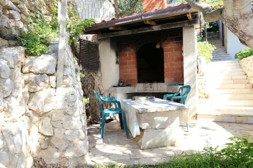 a table and two chairs in a brick oven at Apartments by the sea Pisak, Omis - 1014 in Pisak