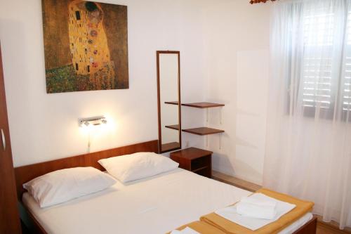 een slaapkamer met een bed en een foto aan de muur bij Apartments by the sea Pisak, Omis - 1014 in Pisak