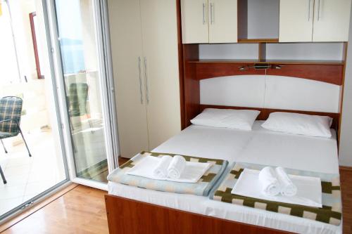 a bedroom with a bed and a sliding glass door at Apartments by the sea Pisak, Omis - 1014 in Pisak