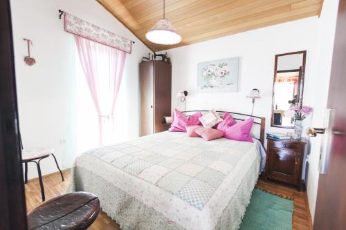 a bedroom with a large bed with pink pillows at Apartments by the sea Seget Vranjica, Trogir - 1037 in Seget Vranjica