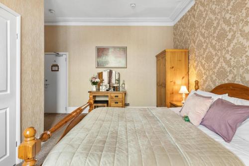 a bedroom with a large bed and a refrigerator at Kings Lodge in Torquay