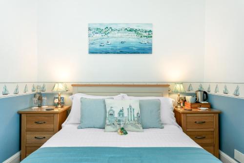 a bedroom with a bed with blue and white at Kings Lodge in Torquay