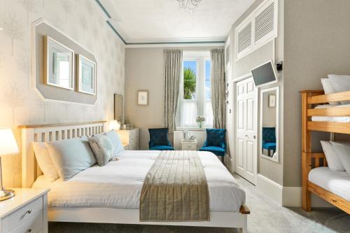 a bedroom with a large white bed and a window at Kings Lodge in Torquay