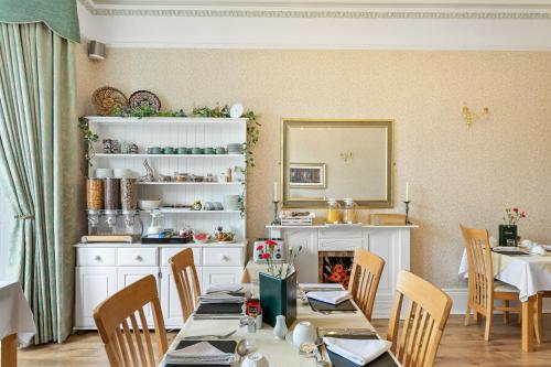 a dining room with a table and chairs and a mirror at Kings Lodge in Torquay