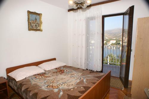 a bedroom with a bed and a window with a view at Apartments by the sea Seget Vranjica, Trogir - 1050 in Seget Vranjica