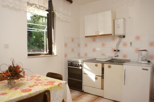 a kitchen with a table and a white refrigerator at Apartment Seget Vranjica 1050b in Seget Vranjica