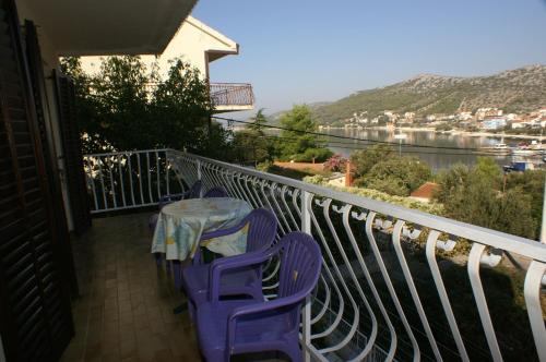 a table and chairs on a balcony with a view at Apartment Seget Vranjica 1050b in Seget Vranjica