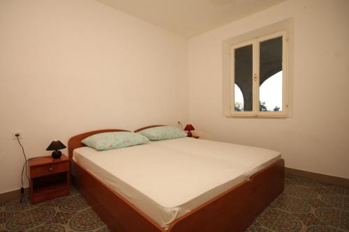 a bedroom with a bed and a window at Twin Room Lucica 990c in Lastovo