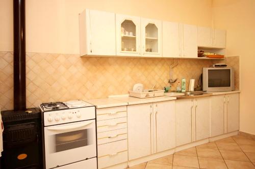 a kitchen with white cabinets and a stove and microwave at Apartments by the sea Tkon, Pasman - 822 in Tkon