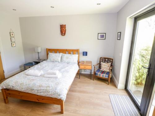 Dunmore的住宿－The Visiting House，一间卧室设有一张大床和一个窗户。
