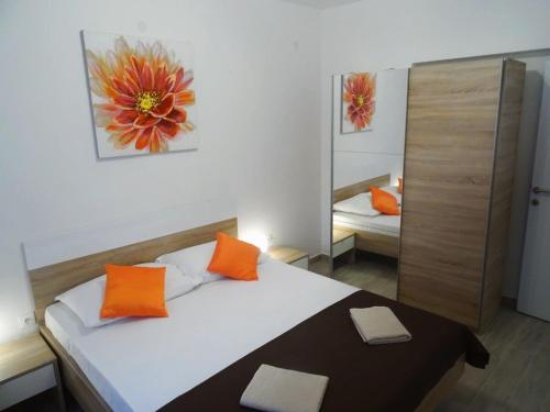 a bedroom with a bed with orange pillows and a mirror at Apartments with a parking space Biograd na Moru, Biograd - 860 in Biograd na Moru