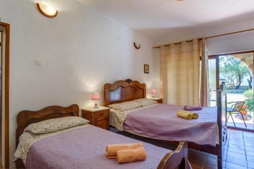 a bedroom with two beds and a balcony at Apartments with a parking space Punta kriza, Cres - 867 in Punta Križa