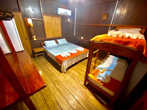 IrandubaにあるAmazonia Jungle Hotelのベッド2台と二段ベッド1組が備わる客室です。