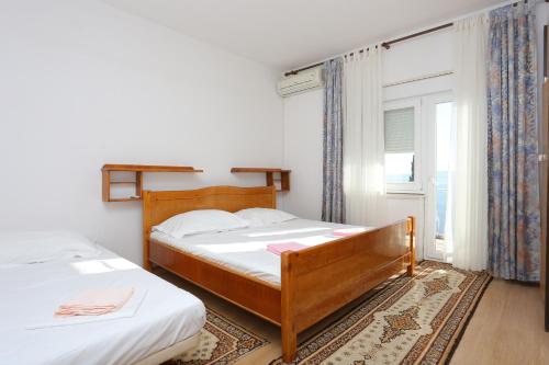 a bedroom with two beds and a window at Apartments with parking space Marusici, Omis - 954 in Mimice