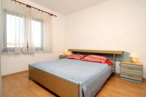 una camera da letto con un letto con due cuscini rossi sopra di Apartments by the sea Ugljan - 846 a Ugljan (Ugliano)
