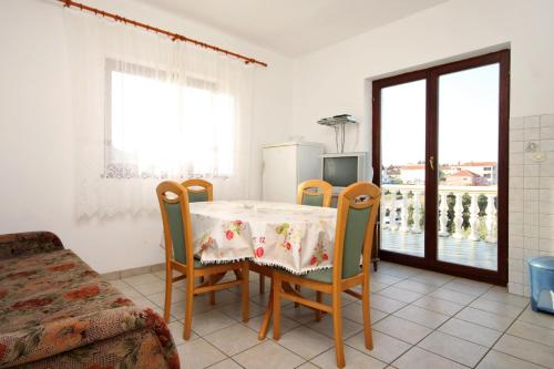 uma sala de jantar com uma mesa e cadeiras e uma janela em Apartments by the sea Ugljan - 846 em Ugljan