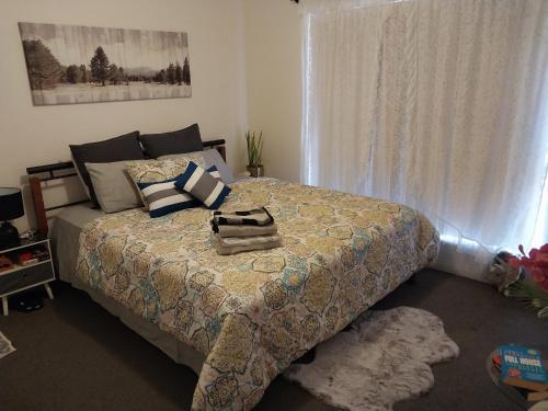 a bedroom with a bed with a blanket and a window at 2BR luxury house in Piccadilly in Kalgoorlie