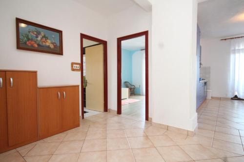 a living room with a tile floor and wooden cabinets at Apartments by the sea Kali, Ugljan - 834 in Kali