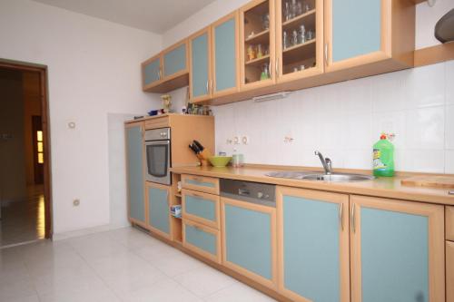 a kitchen with wooden cabinets and a sink at Apartments by the sea Kali, Ugljan - 834 in Kali