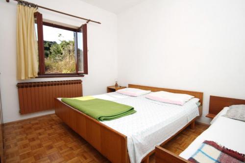 ein kleines Schlafzimmer mit einem Bett und einem Fenster in der Unterkunft Apartments by the sea Savar, Dugi otok - 892 in Brbinj