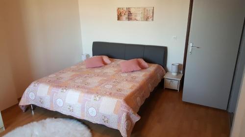 ein Schlafzimmer mit einem Bett mit rosa Kissen darauf in der Unterkunft Apartment Sali 890b in Sali