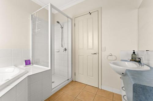 a white bathroom with a shower and a sink at Warley Retreat in Cowes