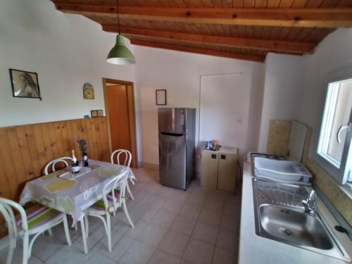 kuchnia i jadalnia ze stołem i lodówką w obiekcie Secluded fisherman's cottage Cove Jaz - Telascica, Dugi otok - 876 w mieście Sali