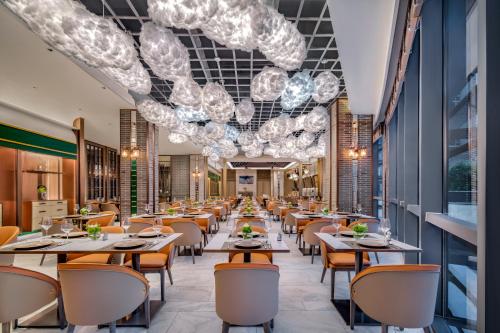 a restaurant with tables and chairs and chandeliers at Harbour Plaza Metropolitan Shanghai in Shanghai