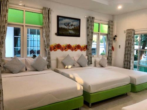 two beds sitting in a room with windows at ฟ้าประทานบูติกรีสอร์ท in Prachuap Khiri Khan