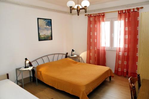 1 dormitorio con 1 cama y una ventana con cortinas rojas en Family friendly seaside apartments Vodice - 928, en Vodice