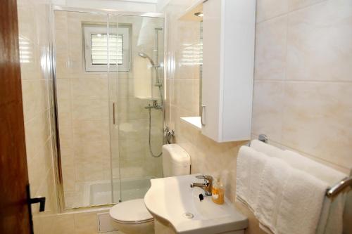 y baño con ducha, aseo y lavamanos. en Family friendly seaside apartments Vodice - 928, en Vodice