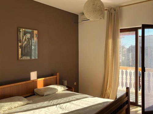 a bedroom with a bed and a large window at Apartments by the sea Brodarica, Sibenik - 919 in Brodarica