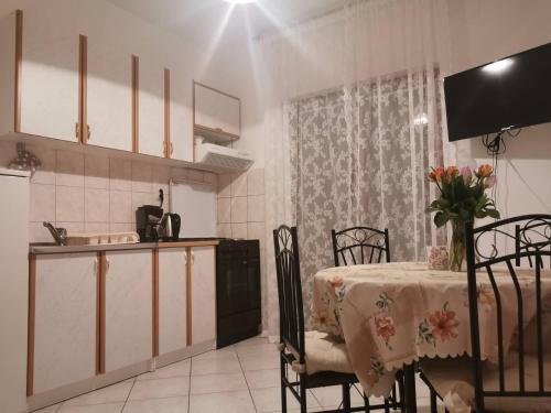 a kitchen with a table and chairs and a kitchen with a table and a table at Apartments by the sea Brodarica, Sibenik - 919 in Brodarica