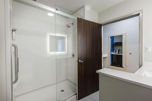uma casa de banho com um chuveiro e uma cabina de duche em vidro. em Holiday Inn Express & Suites Edmonton N - St Albert, an IHG Hotel em St. Albert